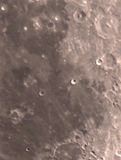 This image is of the south-east region of the Mare Nubium (Sea of Clouds). The interesting Thebit triple crater system  can be seen close to the right side of the image. To the left of that a linear fault known as Rupes Recta can also be seen. Toward the bottom of the image you can see some faint debris trails from the Tycho impact crater.