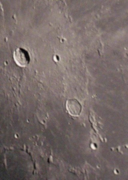 The prominent Kepler crater to the upper right, with its notable 'ray' system, lies on the western edge of the Mare Insularum (Sea of Islands). Below and to the right is the crater Enke, noted for its unusual polygonal shape.